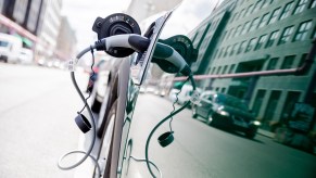 Close-up of a plug-in hybrid SUV attached to a charging cable.