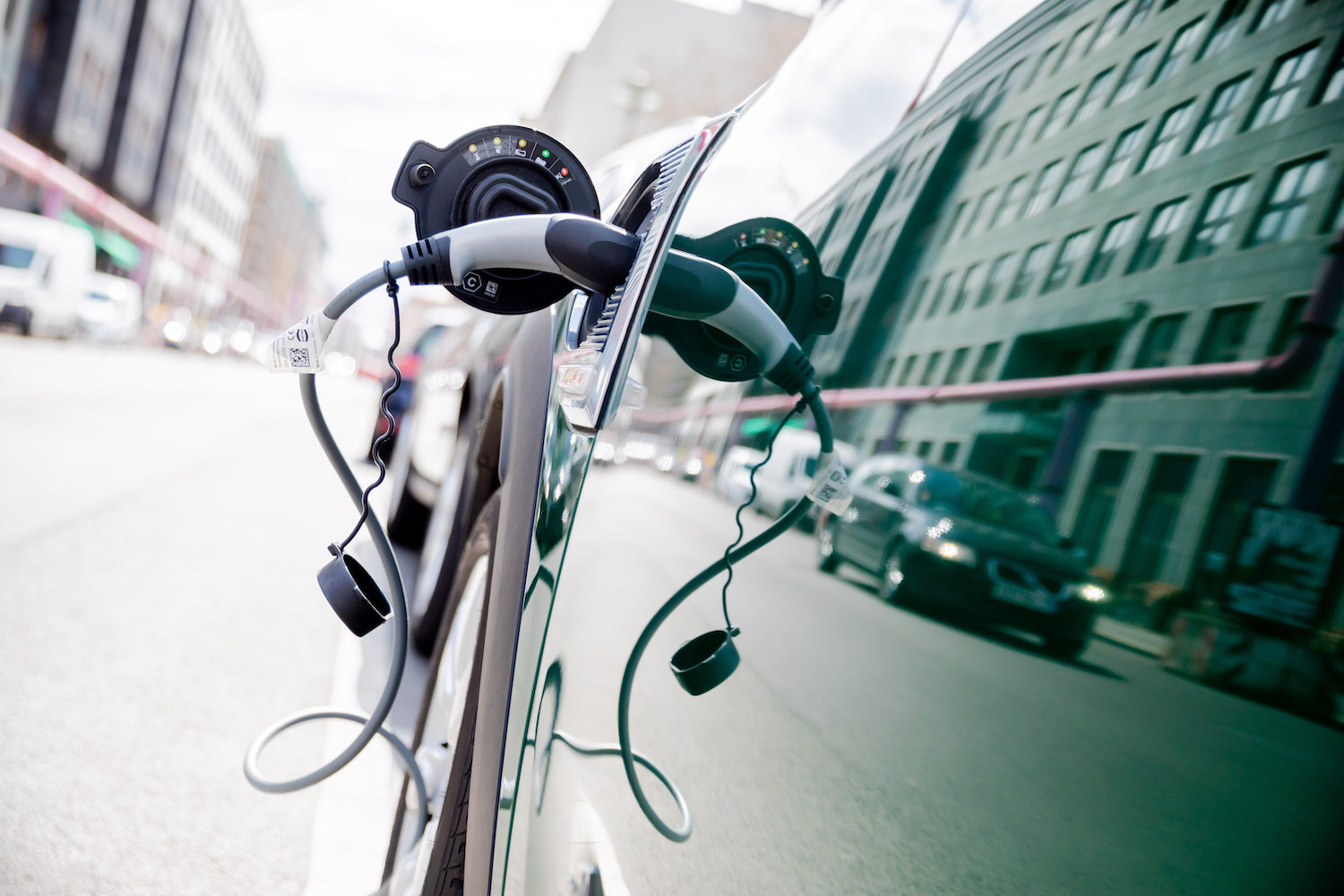 Close-up of a plug-in hybrid SUV attached to a charging cable.