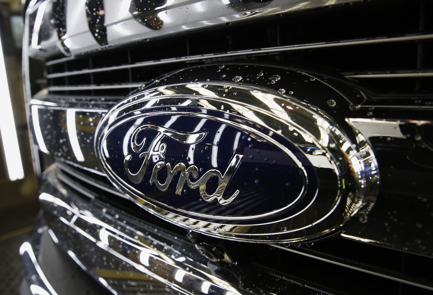 Closeup of the Ford Blue Oval logo on the chrome grille of reliable used F-150 American truck.