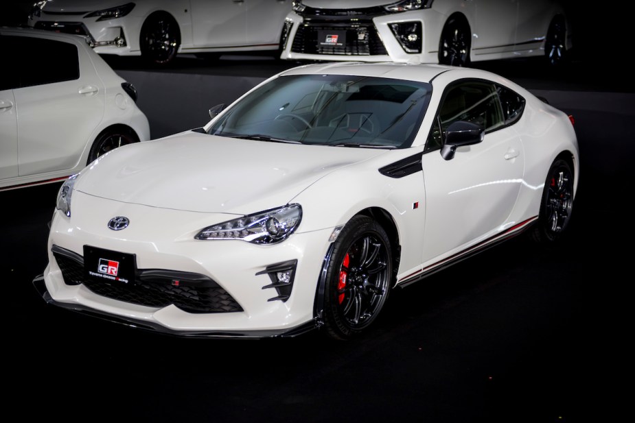 A white Toyota GR86 parked indoors. 