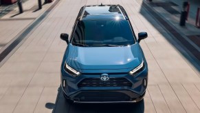 A blue 2022 Toyota RAV4 Hybrid small SUV is driving.