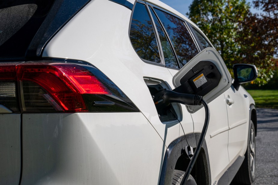 A white Toyota RAV4 Prime PHEV charging. 