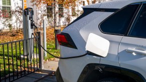 A white Toyota RAV4 Prime charging, which is a plug-in hybrid.