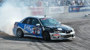 A silver Subaru WRX race car drifting.