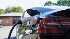 Closeup of an electric vehicle charging on a hot day, a bright blue sky visible in the background.