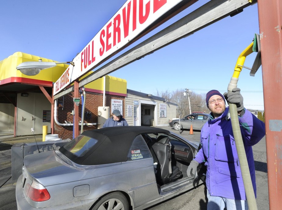 A car wash attendant grabs a vacuum.