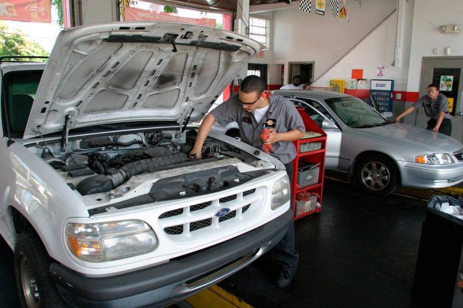 A person changing the oil, potentially with high mileage oil.