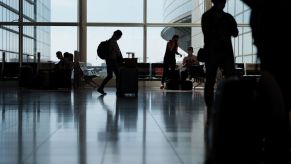 Out-of-Country travel as a passenger pushes luggage through the Haneda Airport in Tokyo, Japan