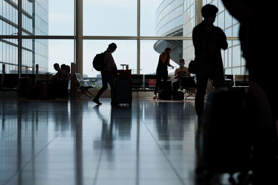 Out-of-Country travel as a passenger pushes luggage through the Haneda Airport in Tokyo, Japan