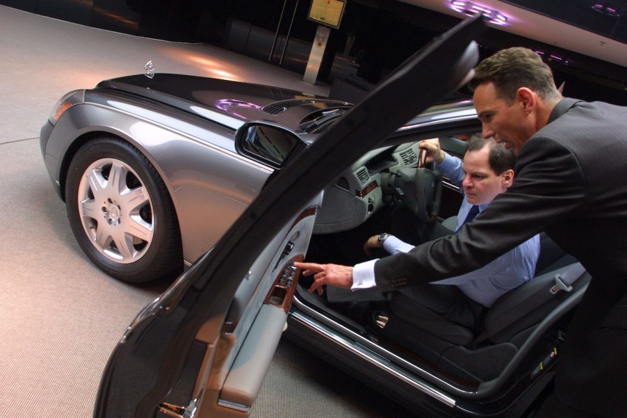 A salesman shows a customer a new car.