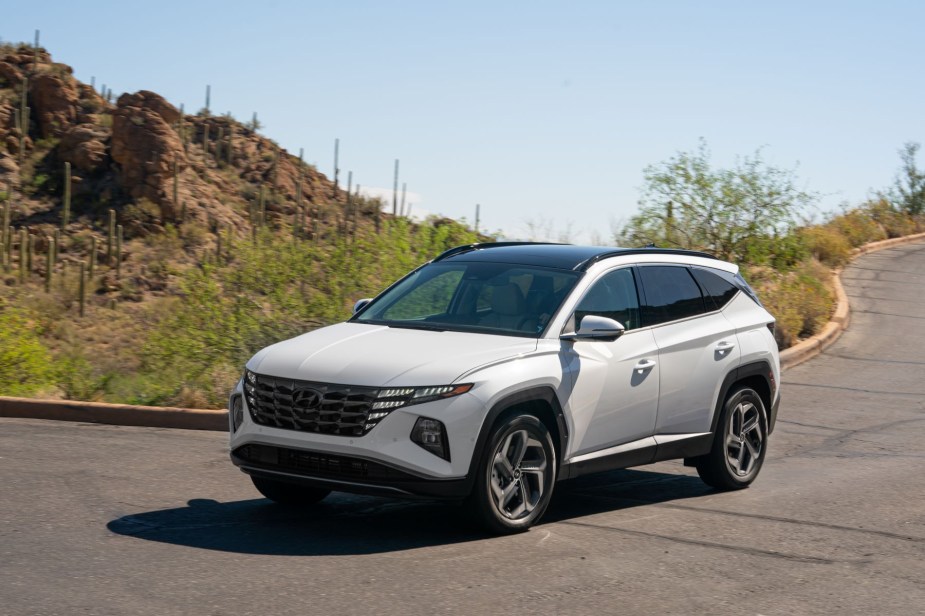 A white 2022 Hyundai Tucson Hybrid compact SUV model parked near a desert cliff