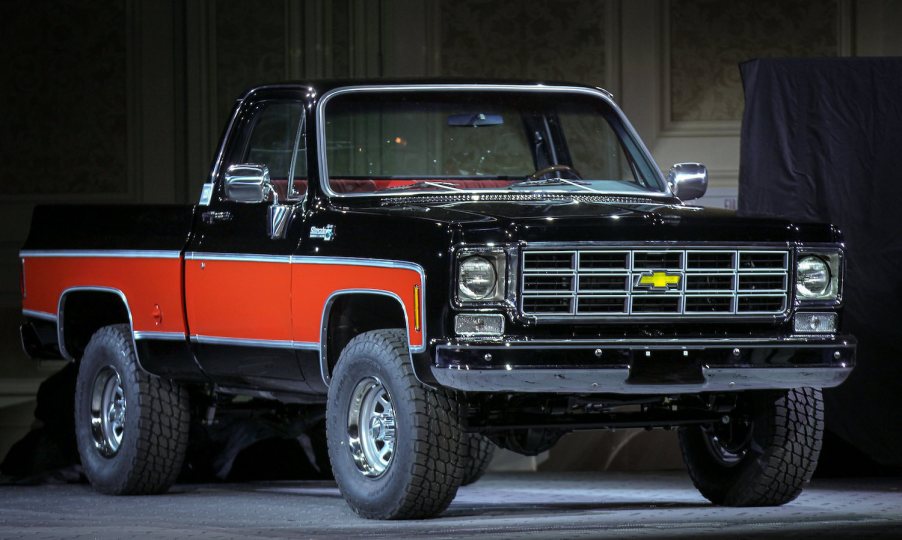 This is a red and black 4x4 square body Chevy truck modified with a modern V8 as a pro-touring off-roader, by Chevrolet for SEMA.