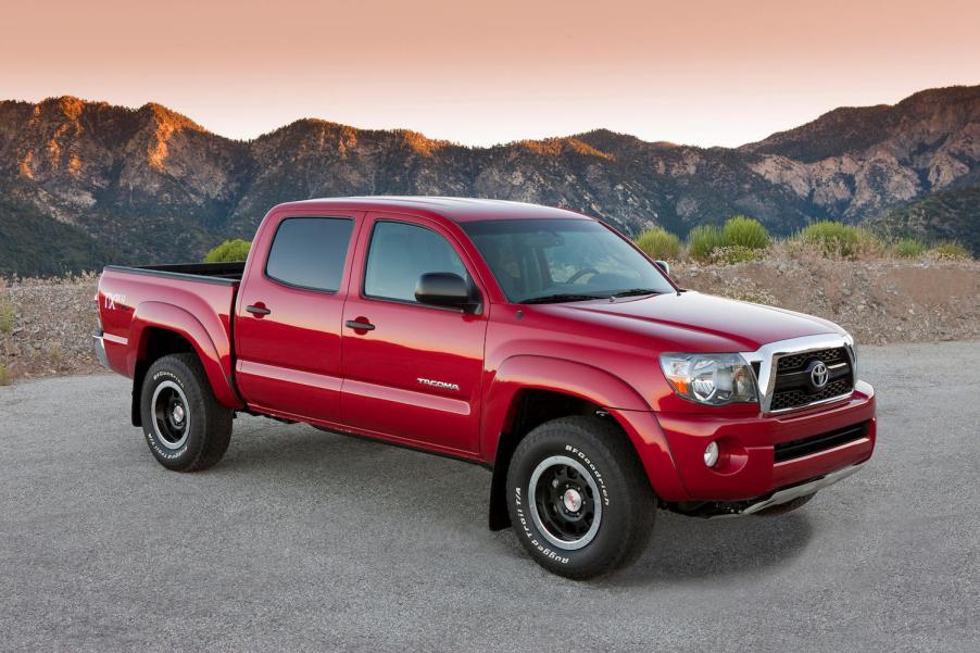 Red 2011 Toyota Tacoma TRD Pro trim parked in front of a mountain range for a promo photo.