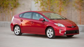 Toyota Prius hybrid driving in front of ivy plants for a promo photo.