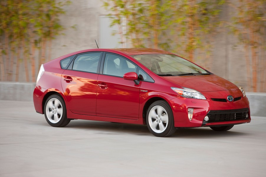 Toyota Prius hybrid driving in front of ivy plants for a promo photo.