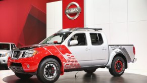 A white and red 2014 Nissan Frontier, reliable small used pickup trucks.