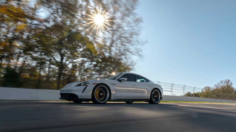 A white 2020 Porsche Taycan luxury car driving