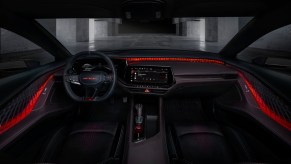 The illuminated interior of Dodge's new Charger Daytona SRT Banshee EV concept car, a concrete garage visible through the windshield.