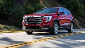 A red 2023 GMC Terrain SLT driving down the road.