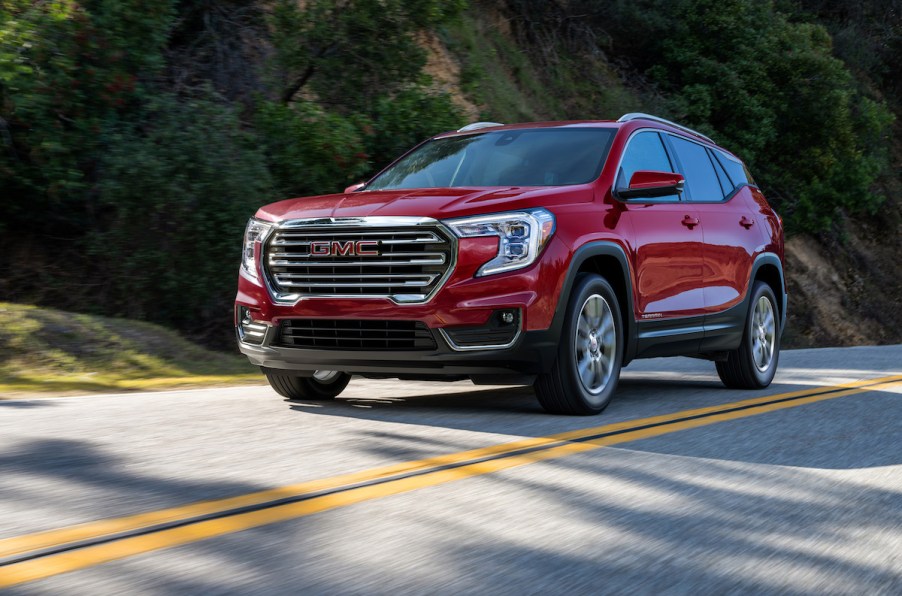 A red 2023 GMC Terrain SLT driving down the road.