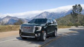 A black 2022 GMC Yukon driving down the road.