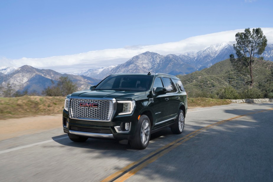 A black 2022 GMC Yukon driving down the road. 