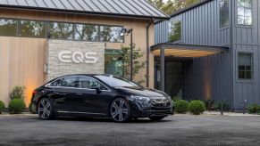 A black 2022 Mercedes-Benz EQS all electric (EV) luxury sedan model parked under its lineup branding logo