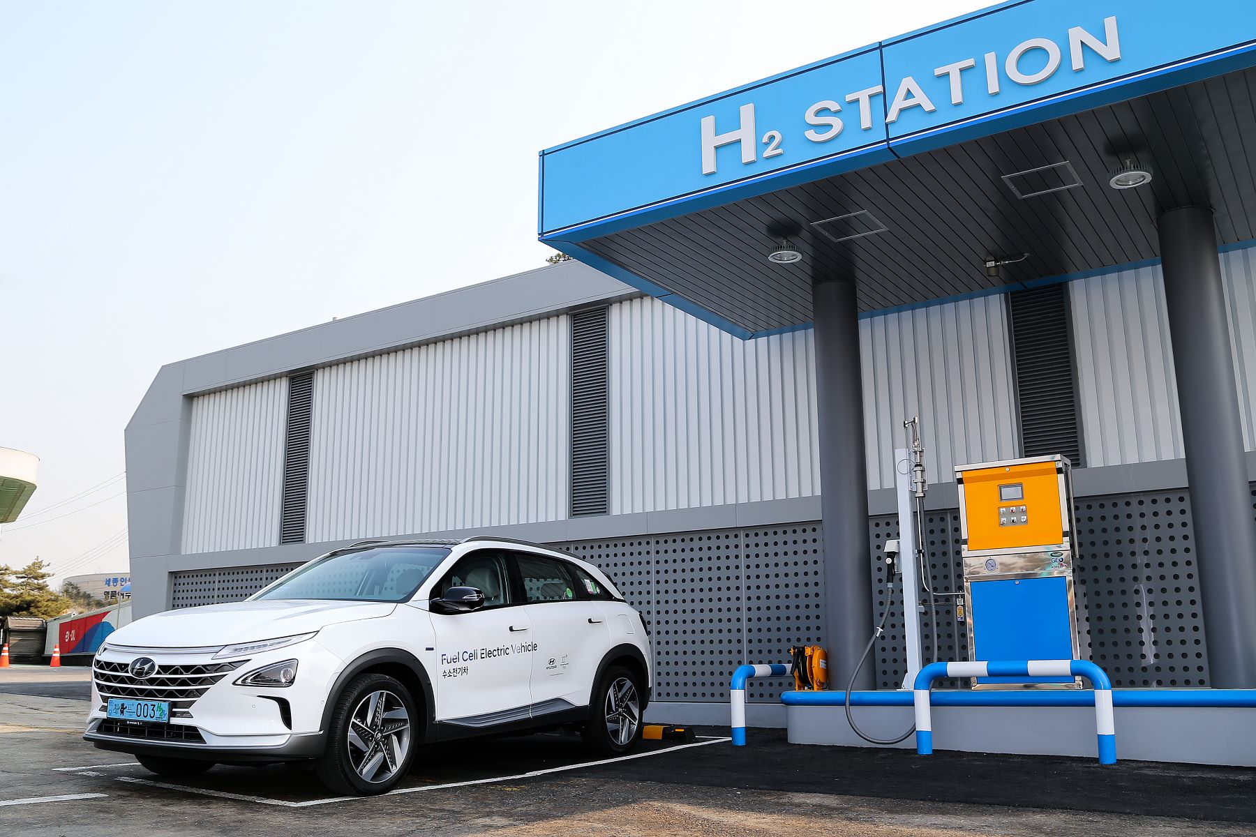 A white 2023 Hyundai Nexo hydrogen fuel cell vehicle at an H2 refueling station