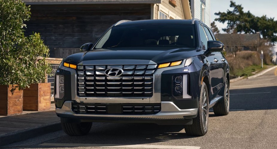 A blue 2023 Hyundai Palisade midsize SUV is parked. 