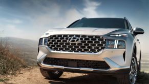 A closeup of the grille of a 2023 Hyundai Santa Fe Plug-in Hybrid midsize SUV model parked on a dirt trail