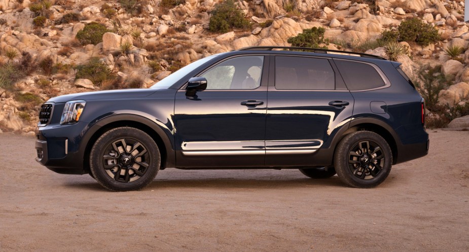 A blue 2023 Kia Telluride midsize SUV is parked outside. 