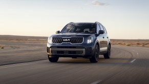 A 2023 Kia Telluride SUV driving at dusk