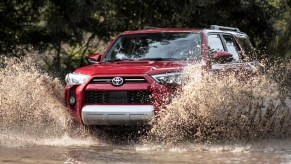 A red 2023 Toyota 4Runner is driving through the water.