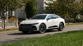 A white 2023 Toyota Crown driving down the road.