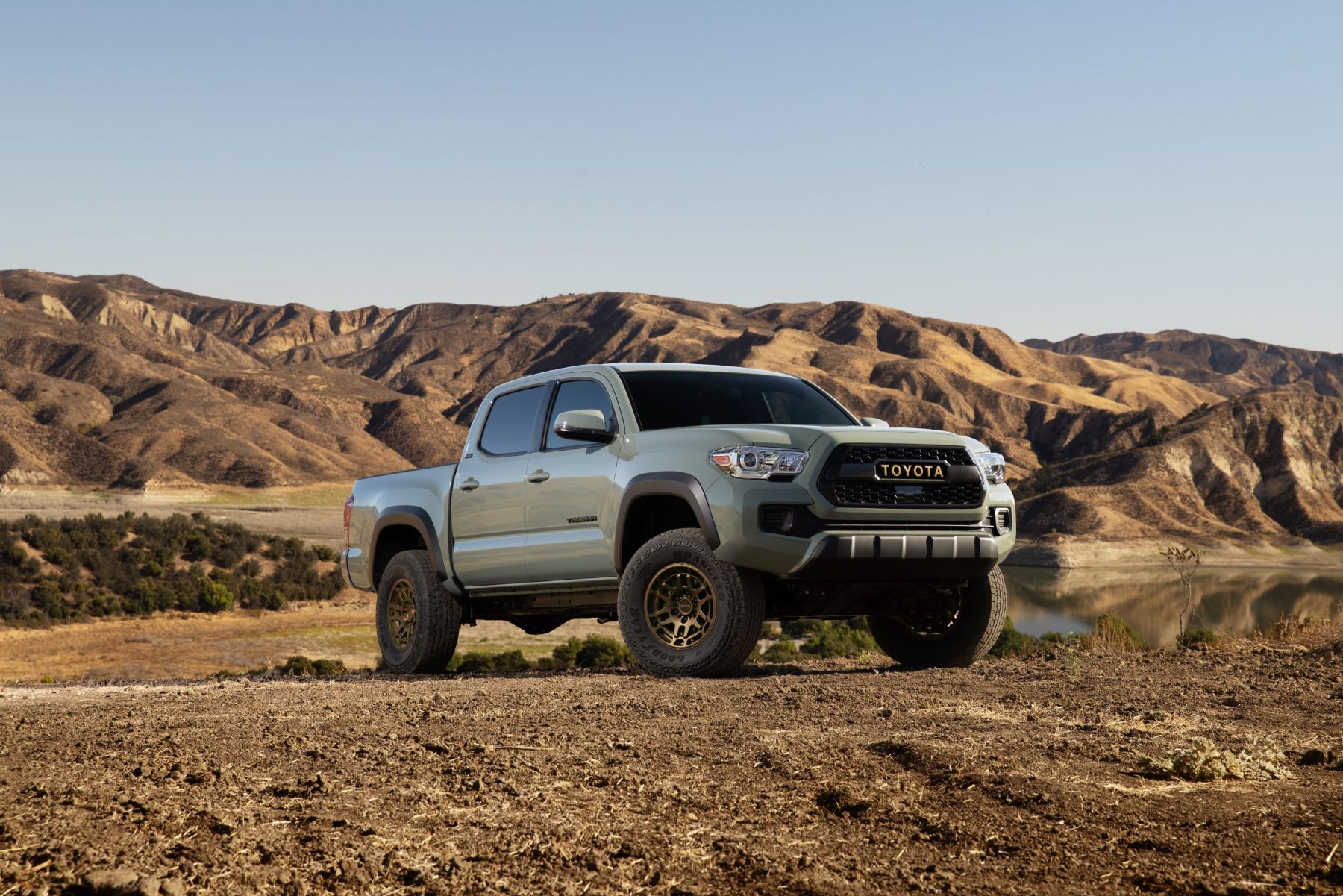 A 2023 Toyota Tacoma Trail Edition midsize pickup truck parked on a plowed dirt field