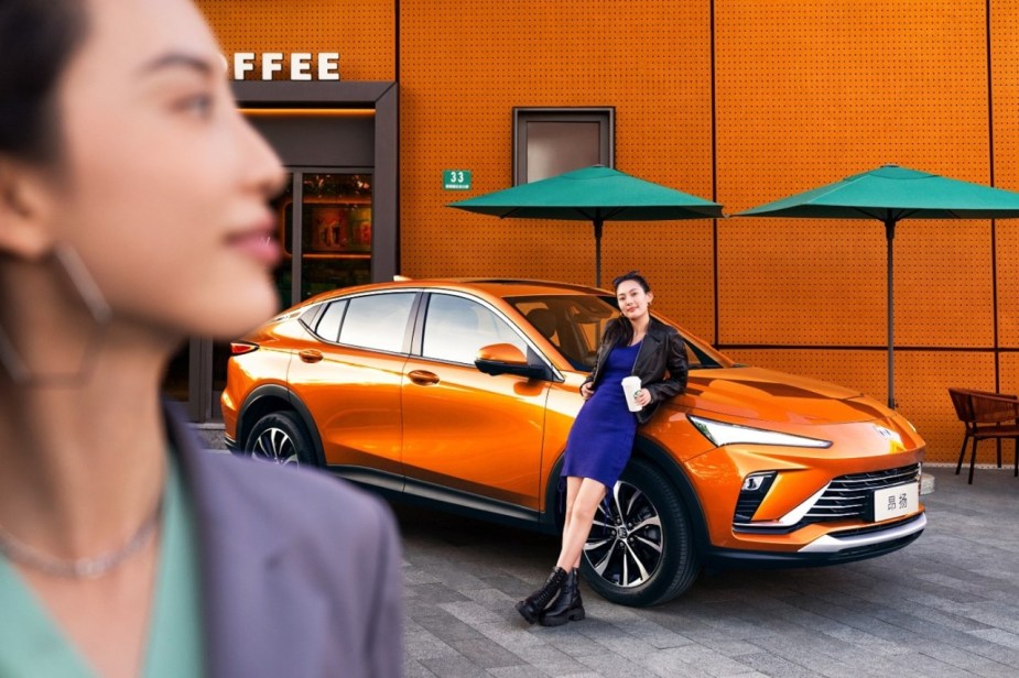 A woman leans on a Buick Envista, the new crossover coming to the U.S.