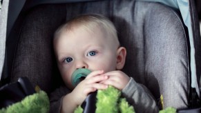 Baby sitting in a car seat, highlighting why some babies hate car seats and how to address it