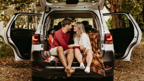 Couple sitting in back of SUV, highlighting how self-driving cars will lead to more sex on the road