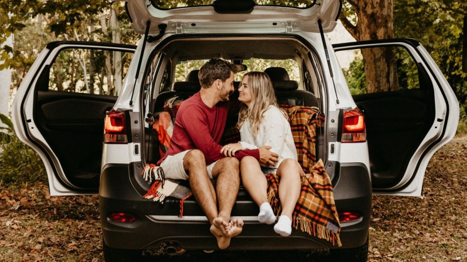 Couple sitting in back of SUV, highlighting how self-driving cars will lead to more sex on the road