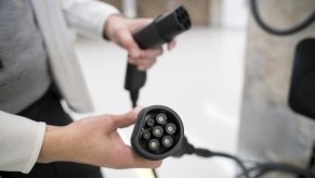 A person holding an EV charger.