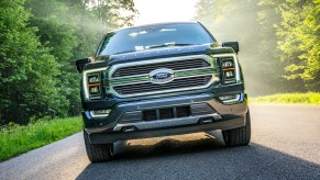 The Ford F-150 driving in a wooded area, which the Ford F-150 hybrid sales are plummeting.