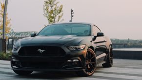 A Black Ford Mustang sports car parked on a cross walk