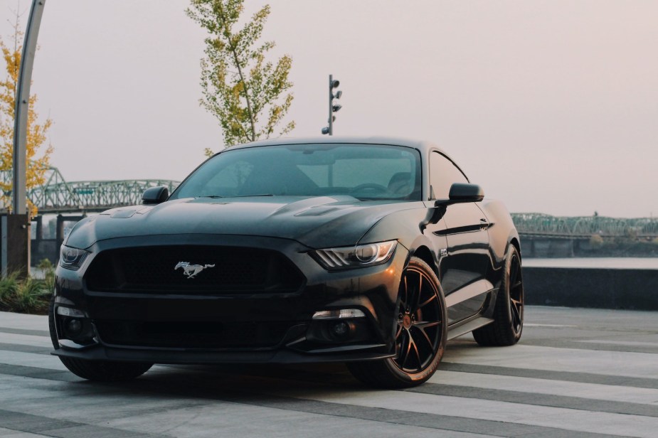 A Black Ford Mustang sports car parked on a cross walk