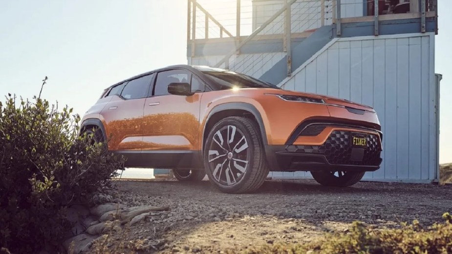 Front angle view of orange 2023 Fisker Ocean crossover SUV EV, which is more affordable than all Tesla models