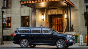 A Jeep Grand Wagoneer full-size luxury SUV parked at a valet station outside of a hotel