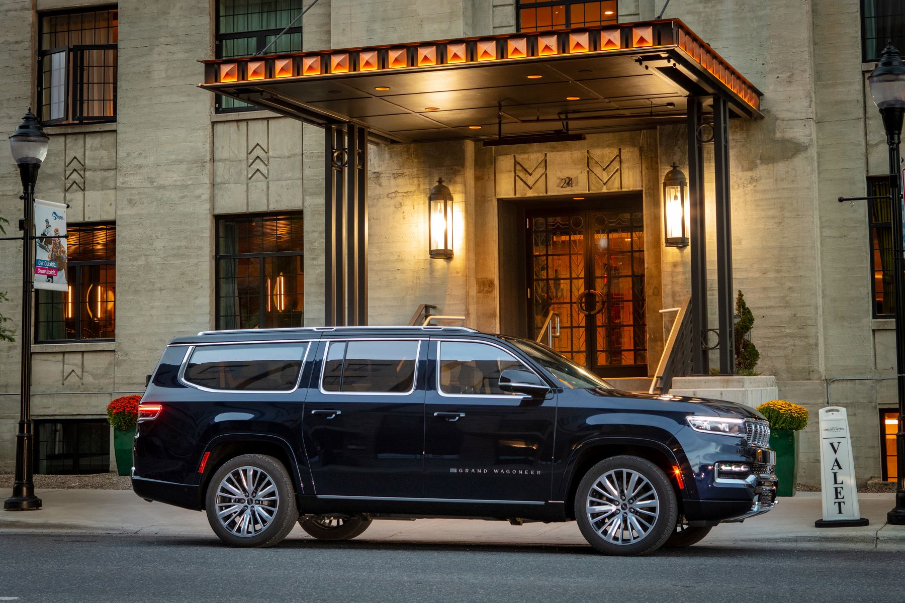 A Jeep Grand Wagoneer full-size luxury SUV parked at a valet station outside of a hotel