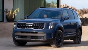 A blue 2023 Kia Telluride midsize SUV is parked.