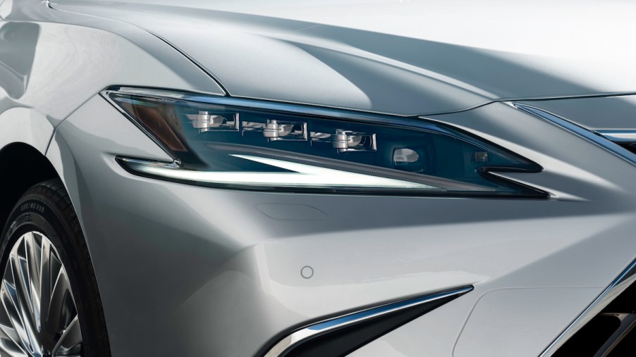 The headlight of a silver Lexus ES luxury hybrid