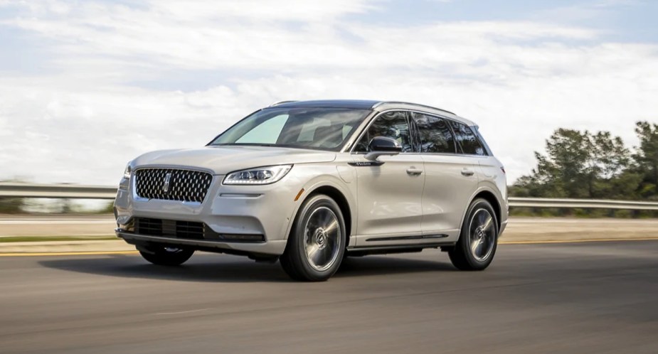 A white 2022 Lincoln Corsair is driving on the road. 