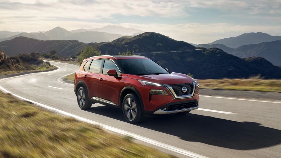 a RED 2023 Nissan Rogue driving on a road. Does the new package make the SV trim worth buying?